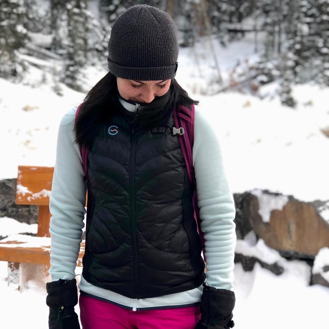Vrouw draagt de Høgge verwarmde bodywarmer in de sneeuw
